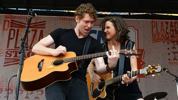 Striking Matches playing accoustic guitars on a stage